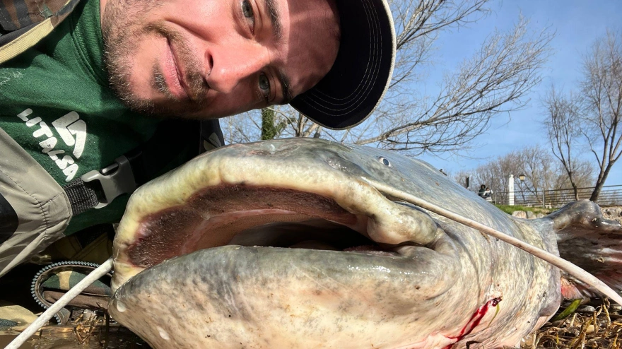 Sergio, aficionado a la pesca en Logroño, junto al siluro recién pescado