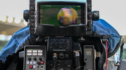 Una cámara de televisión graba durante un partido de fútbol.