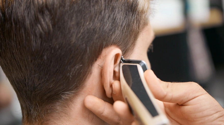 Peluquero cortando el pelo con una maquinilla