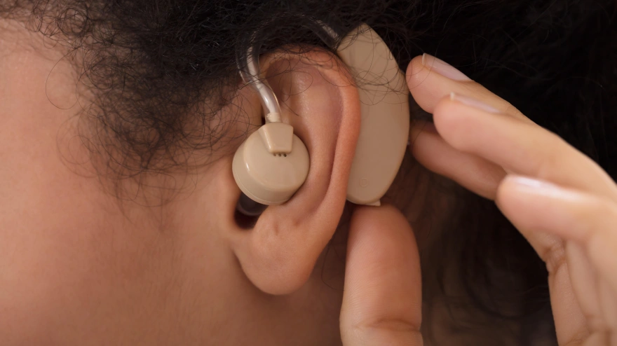Una mujer sorda usa un audífono