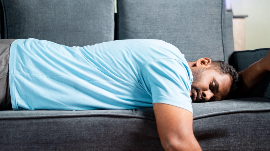 Hombre gordo y cansado durmiendo en un sofá en casa: concepto que muestra descanso, vacaciones de fin de semana y agotamiento debido al exceso de trabajo