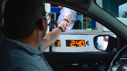 Un hombre paga con efectivo en un peaje