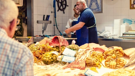 Pescadero en el mercado de Triana preparando pescado para un jubilado