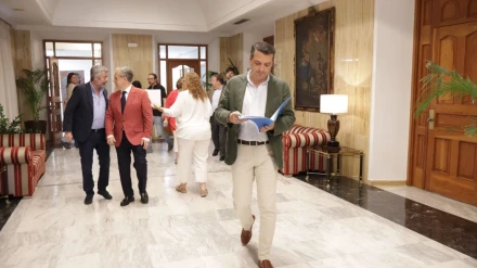 José María Bellido, alcalde de Córdoba, camina por los pasillos del Ayuntamiento con documentación en la mano mientras los va mirando