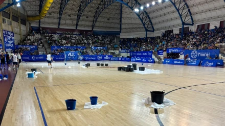 La pista del Palau d'Esports de Alzira, llena de cubos durante un partido de ascenso a Primera División en fútbol sala