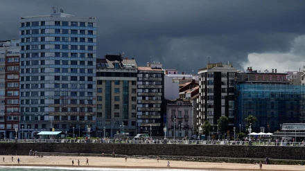 Vista de la playa de San Lorenzo con nubes oscuras de tormenta al fondo