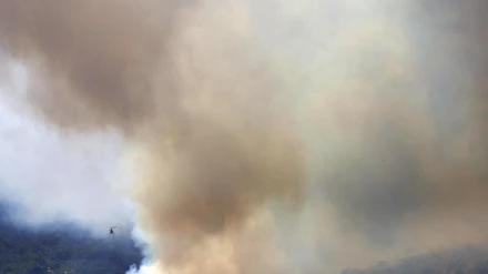 Un helicóptero trabaja en la tareas de extinción del incendio forestal de alta intensidad que se inició ayer en Paüls