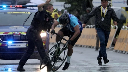 Un miembro de seguridad intercepta a un individuo en la meta de la 17ª etapa del Tour
