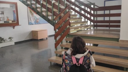 Olaya, frente a la escalera de su centro educativo, donde gracias a la instalación de un salvaescaleras, podrá acceder a sus clases sin barreras