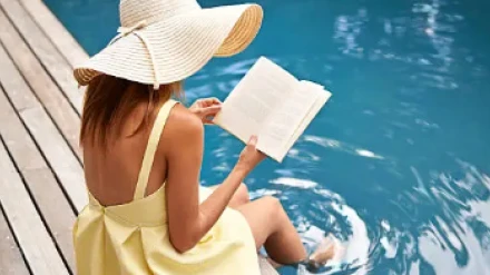 Una bañista disfruta leyendo un libro en una piscina