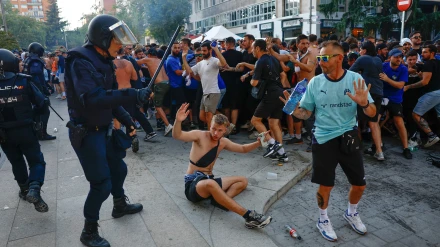 Un agente de policía carga contra uno de los radicales del Marsella en los aledaños del Santiago Bernabéu
