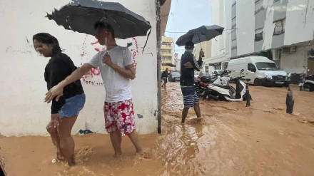 Personas caminan por calles anegadas en Ibiza debido a las intensas lluvias