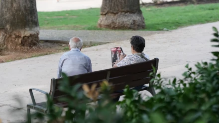 Dos personas sentadas en un banco en Barcelona