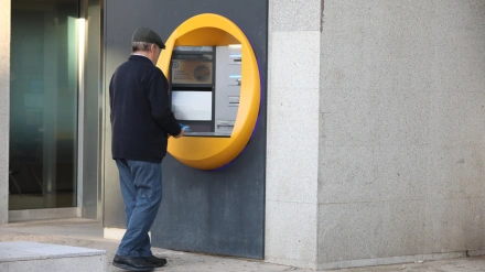 Un hombre ingresa dinero en un cajero automático