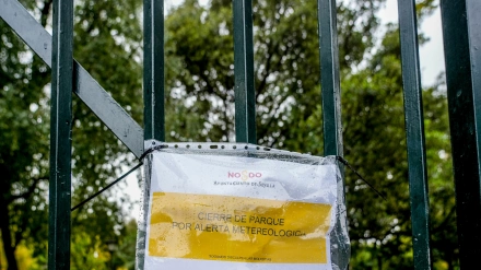 Archivo - Cartel en una reja de entrada al Parque de María Luisa de Sevilla que indica el cierre por alerta meteorológica en octubre de 2023. Imagen de archivo.