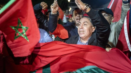 La gente ondea banderas y celebra en una calle de Rabat.