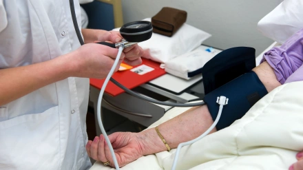 Una enfermera está midiendo la presión arterial de un paciente en un hospital