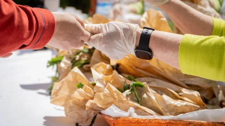 Hombre pagando en efectivo sus compras en el mercado del festival del ajo asado en Arnedo, La Rioja