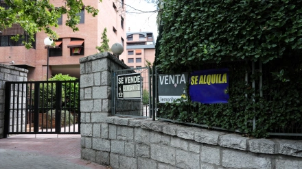 En la valla de una urbanización, se ven colgados dos carteles de 'Se vende piso' y uno de 'Se alquila'.