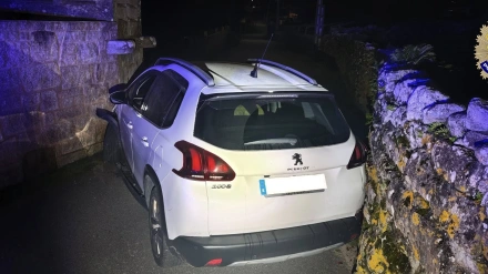 Imagen del coche empotrado entre dos muros en Ribeira