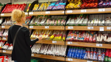 Una mujer enfrente de una estantería de un supermercado
