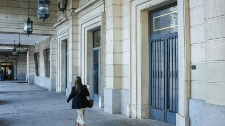 Archivo - Una mujer camina hacia la Audiencia de Sevilla en imagen de archivo.