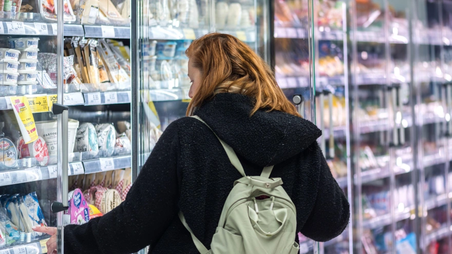 Una mujer saca un producto de la nevera de un supermercado en Madrid