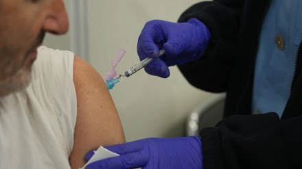 Una persona se vacuna, en un centro de refuerzo de vacunación frente a la gripe