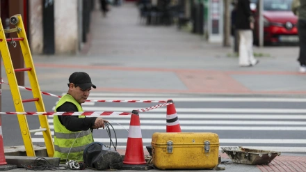 Un trabajador tira cable de telecomunicaciones en una calle de Bilbao