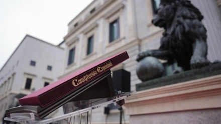 Ejemplar de la Constitución Española colocado ante los leones que custodian la entrada principal del Congreso de los Diputados antes del acto institucional por el Día de la Constitución