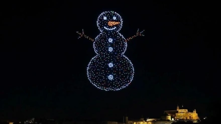 Drones en el cielo nocturno formando un muñeco de nieve y al fondo se ve iluminada la Mezquita-Catedral de Córdoba