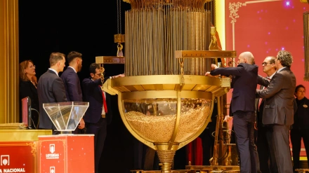 Trabajadores de Loterías y Apuestas del Estado preparan las bolas con los números para introducirlas en el tambor durante los reparativos para el inicio del Sorteo Extraordinario de Navidad