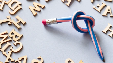 2X8A9WF Pencil with knot and scattered letters, dyslexia concept