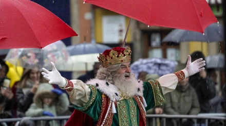 El Rey Melchor protegiéndose de la lluvia durante una cabalgata de Reyes