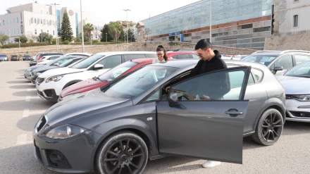 Dos jóvenes compartiendo vehículo en el aparcamiento del Campus Muralla del Mar