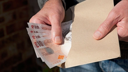 Un hombre cuenta billetes en libras británicas