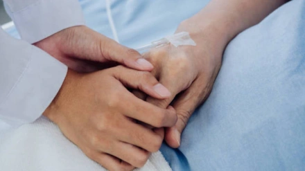 La mano de un paciente agarrada por una mano de un familiar