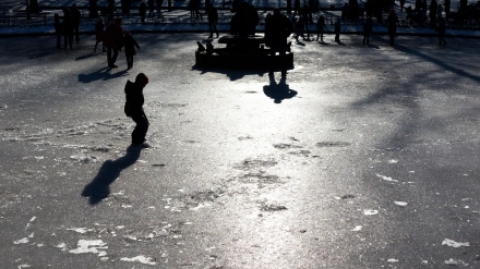 Niños jugando sobre la superficie de una fuente helada.