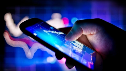 Una persona que usa un teléfono móvil para realizar un seguimiento de los datos bursátiles en tiempo real.