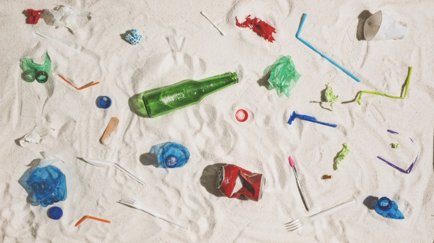 Polluted beach with plastic, glass waste and assorted rubbish: environmental protection and plastic pollution concept