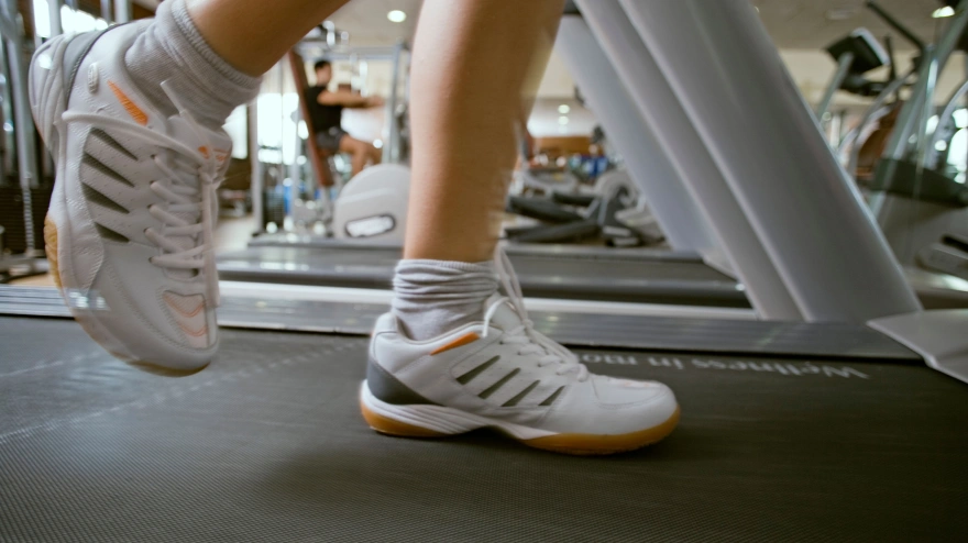 Una persona corriendo en una cinta en un gimnasio, imagen de archivo