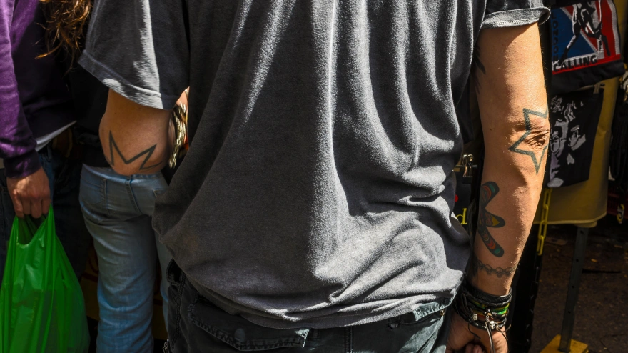 Un hombre de espaldas con los brazos tatuados en el Rastro de Madrid