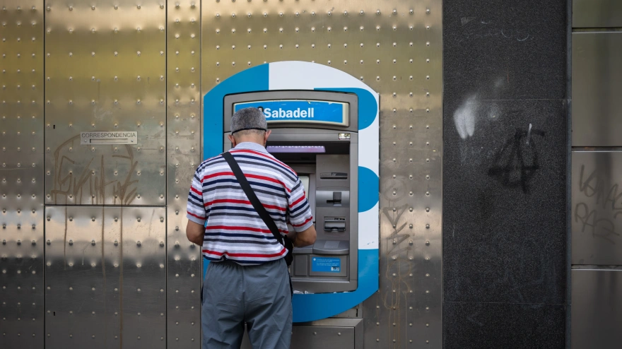Un hombre saca dinero en el cajero de un banco