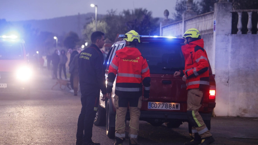 Efectivos del cuerpo de Bomberos de Córdoba desalojan a vecinos de una urbanización ante la crecida del río Guadalquivir para alejarlos de las zonas inundables