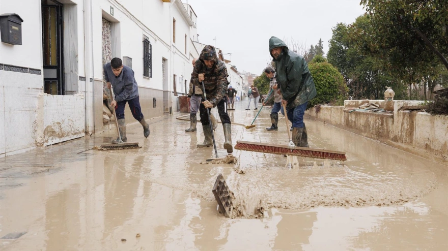 Vecinos de Villanueva Mesía se afanan en sacar el agua y barro de sus casas tras la crecida del Río Genil por el paso de la borrasca 'Leonardo'