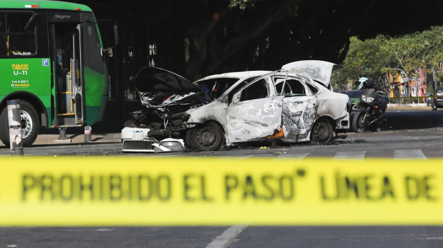 Fotografía que muestra un bloqueo con vehículos incendiados este domingo, en una vía de Guadalajara (México).