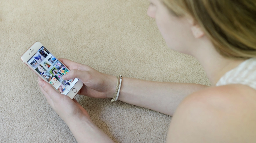 Adolescente utilizando la aplicación de redes sociales Instagram en su teléfono móvil