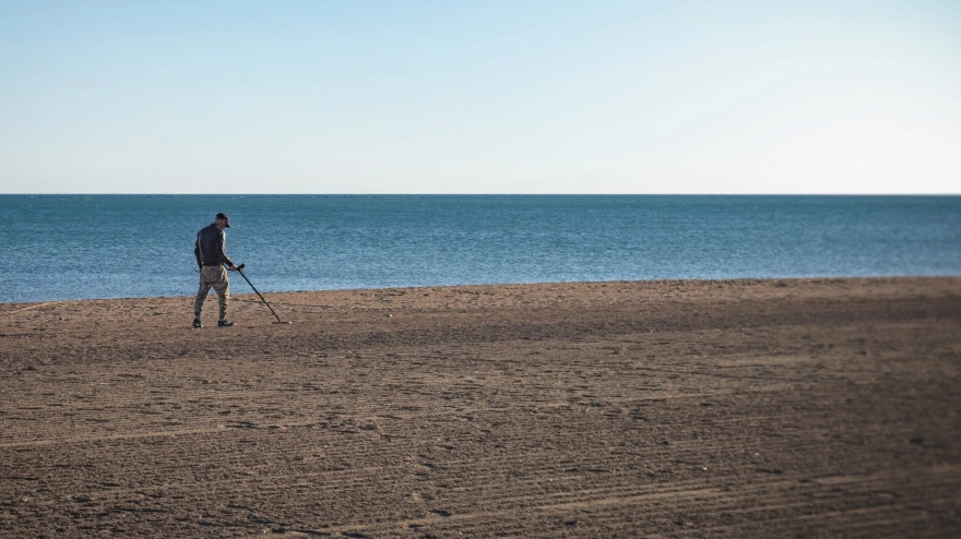 Un aficionado a la detección de metales, en la playa