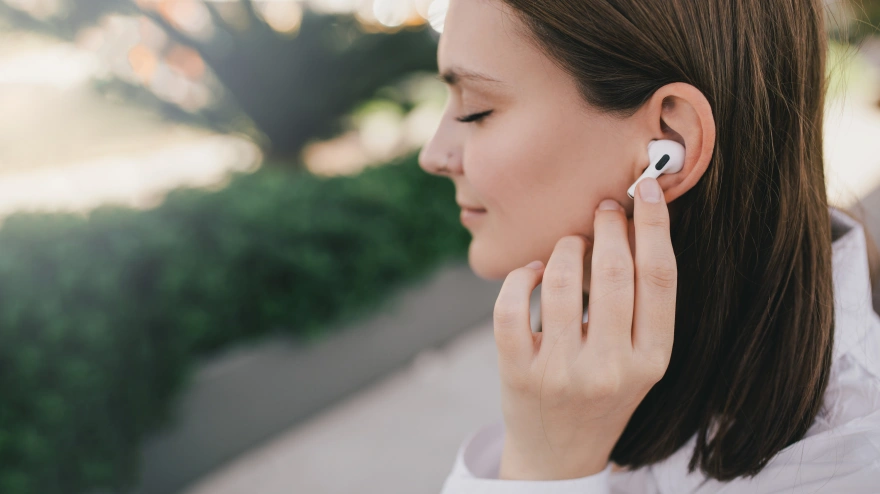 Una mujer escucha la radio con unos auriculares inalámbricos