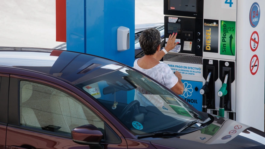 Una mujer antes de echar carburante a su vehículo en una estación de servicio.